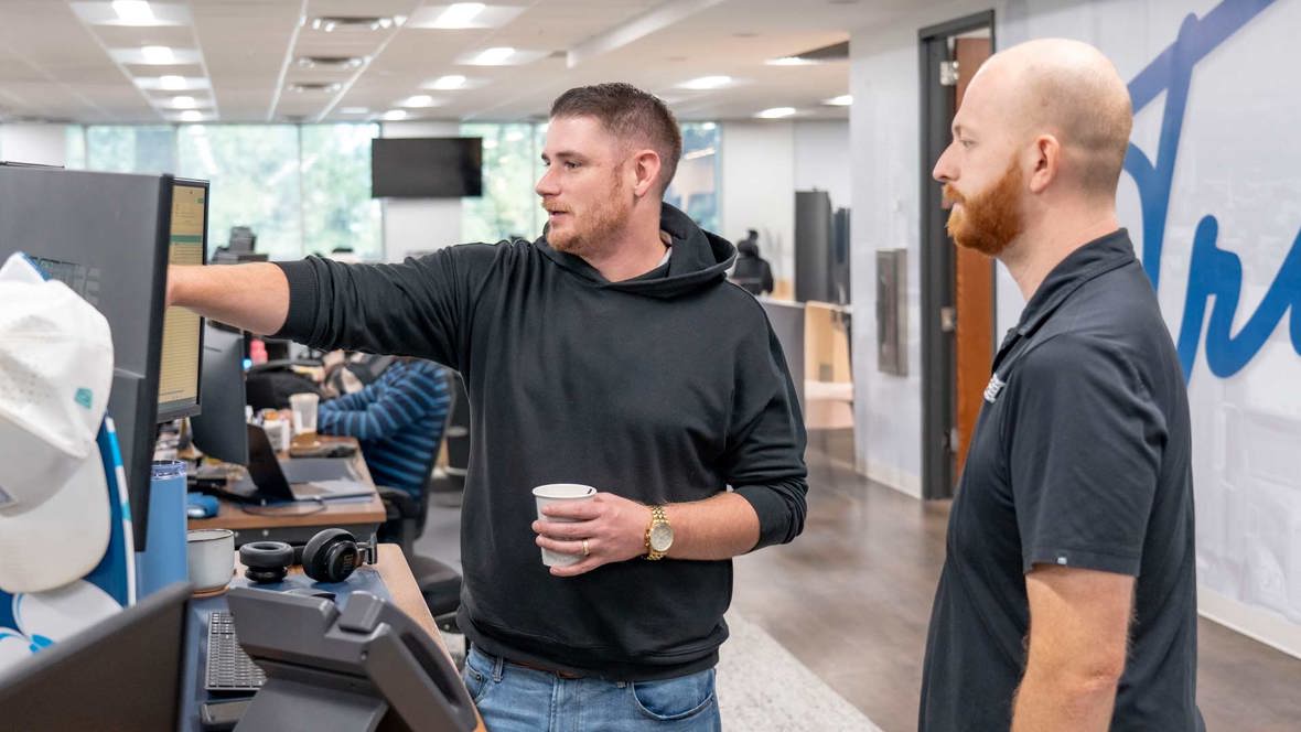 Zach And Coulson Standing At Desk Web